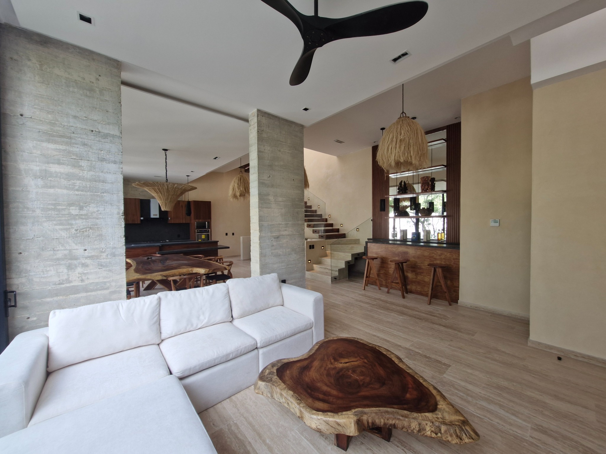 Sala de una villa Zakktal con acabados naturales y cocina integrada.
