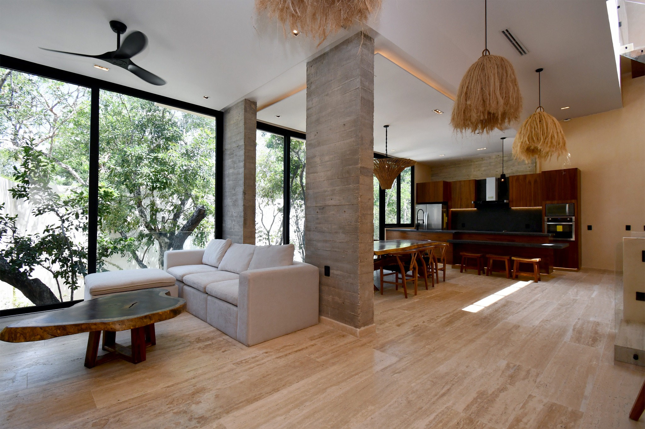 Área social abierta de una villa Zakktal rodeada por vegetación tropical.